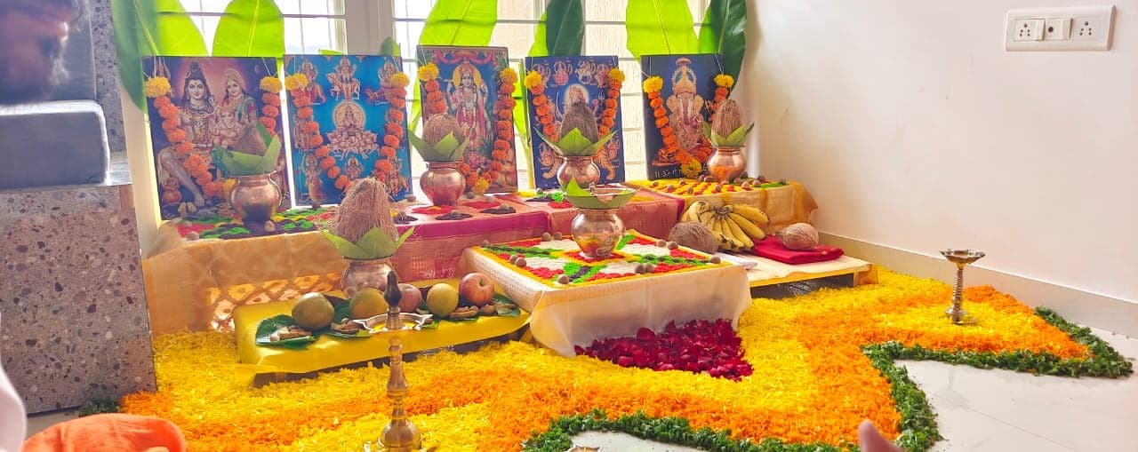 Deity portraits garlanded with marigold above kalash