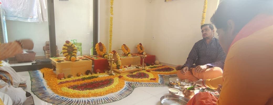 A family seated for puja with the pandit ji